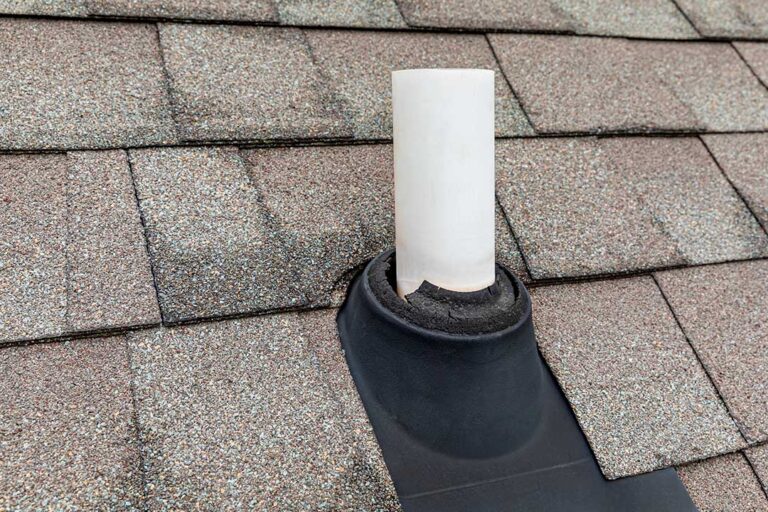 Homeowner inspecting gutters and roof edges beside a house before a severe rainstorm.